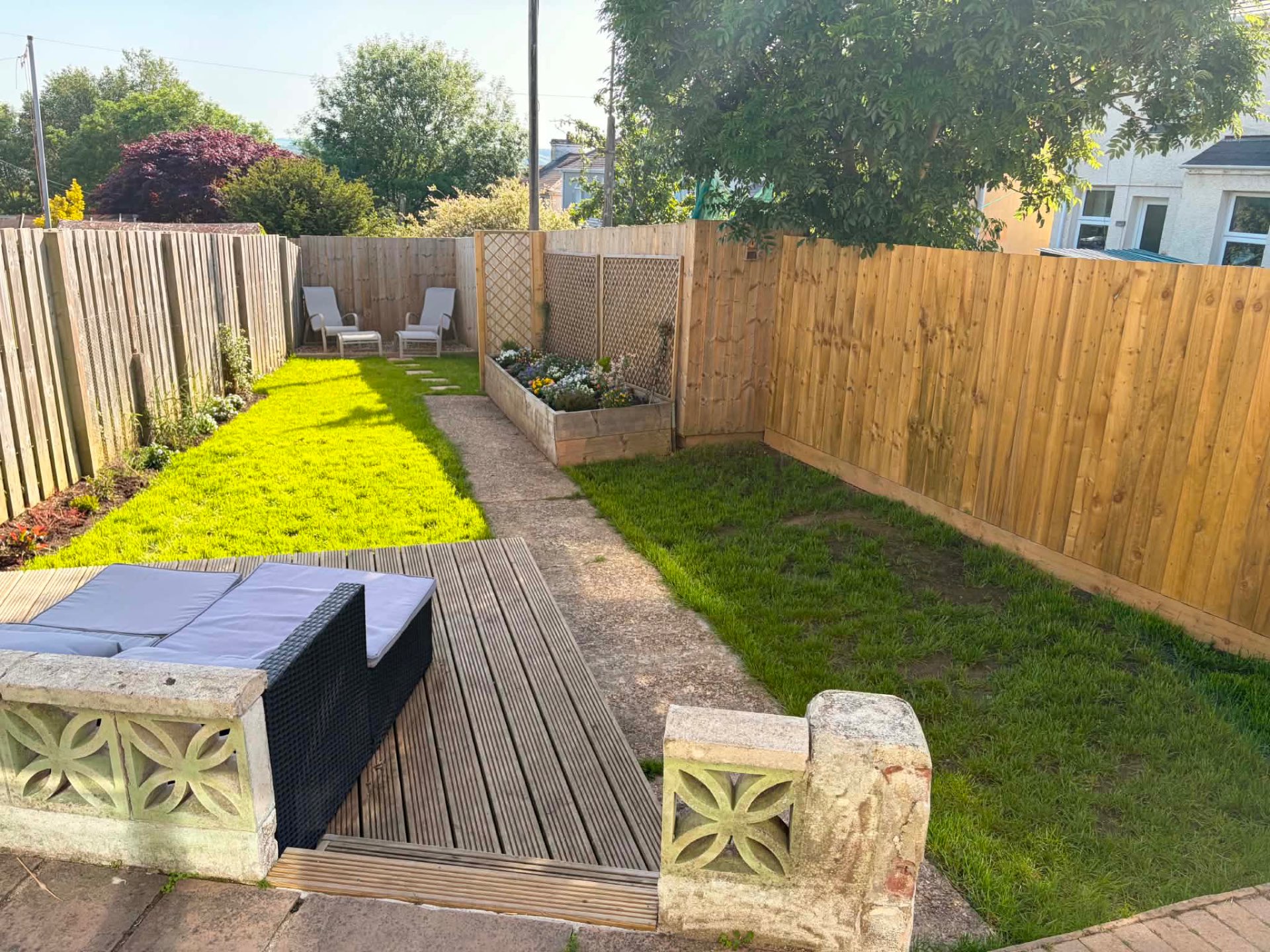 Finished back garden with fresh lawn, planted raised bed and new timber fencing